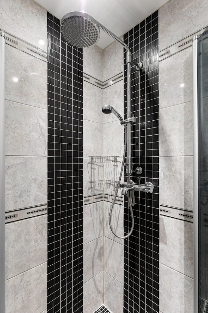 Sleek modern shower with black and white tiles in a contemporary bathroom setting.